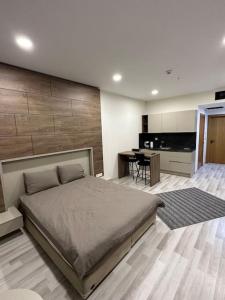 a bedroom with a large bed and a kitchen at Kartepe Dedeman’da Rezidans in Kartepe