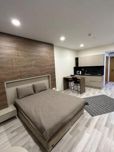 a bedroom with a large bed and a kitchen at Kartepe Dedeman’da Rezidans in Kartepe
