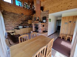 a kitchen and dining room with a table and a fireplace at Saules Street Home in Kuldīga
