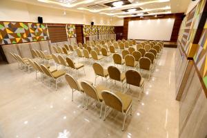 uma sala de conferências com mesas e cadeiras e um quadro branco em Chetinaad Courtyard Gandhipuram by Centre Park em Coimbatore