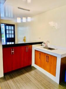 uma cozinha com armários vermelhos e um lavatório em Elliannah Pines Hotel em Baguio
