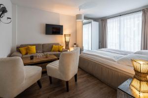 ein Schlafzimmer mit einem Bett, einem Sofa und einem Tisch in der Unterkunft Hotel Luina Beach in Büsum