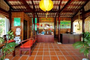 a restaurant with a woman sitting at a counter at Green Areca villa in Hoi An