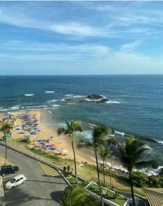 una playa con palmeras, sombrillas y el océano en ONDINA SSA, en Salvador 2 fotos más