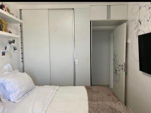 a bedroom with white walls and a bed with white sheets at ONDINA SSA in Salvador