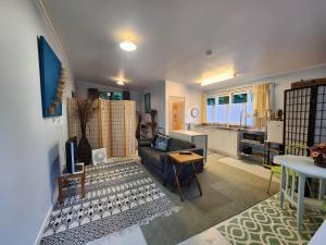 ein Wohnzimmer mit einem Sofa und einem Tisch in der Unterkunft La Petite Ferme Studio Kerikeri in Kerikeri