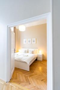 a white bedroom with a bed and a mirror at Danube Waterfront View at Chain Bridge in Budapest