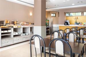 uma cozinha com mesa e cadeiras numa cafetaria em Hotel Victoria Valdemoro em Valdemoro