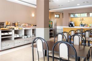 una cocina con mesa y sillas en una cafetería en Hotel Victoria Valdemoro, en Valdemoro