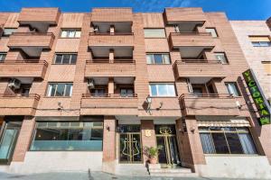 a red brick building with a front door at Hotel Victoria Valdemoro in Valdemoro