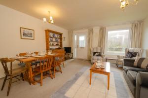 a living room with a table and a dining room at 18 Thrang Brow in Ambleside