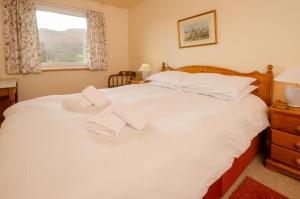 - une chambre avec un lit blanc et des serviettes dans l'établissement 18 Thrang Brow, à Ambleside