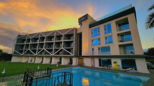 a building with a swimming pool in front of it at Gladsheim Hotel in Seogwipo