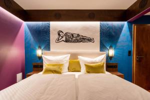 a bedroom with a large white bed with yellow pillows at Hotel Luina Beach in Büsum
