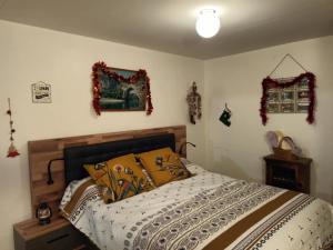 1 dormitorio con 1 cama y algunas decoraciones en la pared en Le cocon, en Rochecolombe