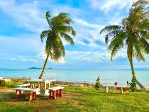 ein Picknicktisch und zwei Palmen am Strand in der Unterkunft Ava Beach Pakbara in Ban Pak Ba Ra