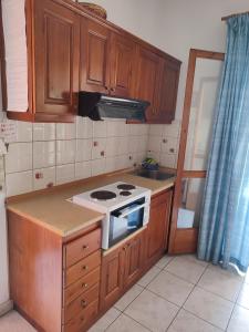 a kitchen with wooden cabinets and a stove top oven at Villa marina apartment2 in Ipsos +8 photos