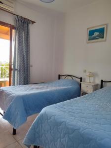 two beds in a hotel room with a window at Villa marina apartment2 in Ipsos