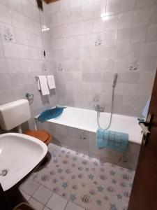 een badkamer met een bad, een toilet en een wastafel bij Apartma Tilika in Kranjska Gora