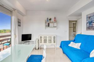 een woonkamer met een blauwe bank en een tv bij Los Molinos in Denia