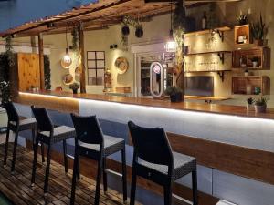 um bar com quatro cadeiras sentadas num balcão em Castilho 63 Hostel & Suites em Lisboa