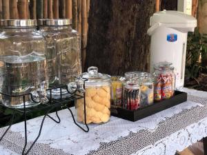 a table with jars of food and drinks on it at Lanna House Lanna Hut Chiangmai in Chiang Mai