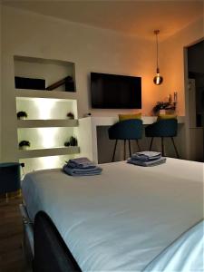 1 dormitorio con 1 cama con 2 sillas y TV de pantalla plana en - La Casa delle Meraviglie- Porta Romana Edition, en Milán