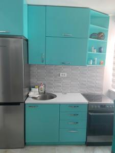 a kitchen with blue cabinets and a sink at Elite in Ostrovo