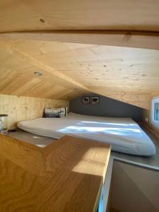 Ce lit se trouve dans une petite chambre dotée d'un plafond en bois. dans l'établissement Tiny House Ruhr im PIER9 Tiny House Hotel, à Hamm