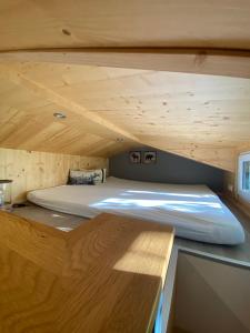 a bed in a small room with a wooden ceiling at Tiny House Ruhr im PIER9 Tiny House Hotel in Hamm