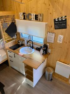 un baño con lavabo en una casa pequeña en Tiny House Ruhr im PIER9 Tiny House Hotel, en Hamm