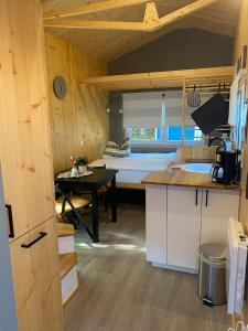 cocina con mesa y habitación con cama en Tiny House Ruhr im PIER9 Tiny House Hotel, en Hamm