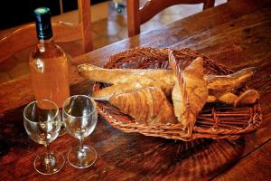 - un panier de pain et deux verres à vin sur une table dans l'établissement Maison Monbazillac avec piscine 2-4 pax, à Monbazillac 1 autre photo