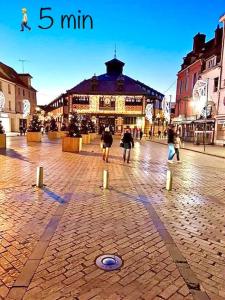 eine Gruppe von Menschen, die vor einem Gebäude spazieren gehen in der Unterkunft Le Led Room,Centre ville place de parking gratuite in Sens