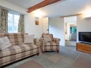 a living room with two couches and a television at Yew Tree Cottage in Branscombe