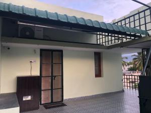 Single room Homestay Second floor في بالني: مبنى ابيض صغير مع باب وشرفة
