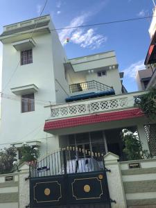 Single room Homestay Second floor في بالني: مبنى ابيض كبير مع شرفة وبوابة