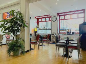 a dining room with tables and chairs and a clock at Enzo Hotels Limoges Centre Jourdan by Kyriad Direct in Limoges