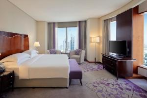 a hotel room with a bed and a television at Rose Rayhaan by Rotana - Dubai in Dubai