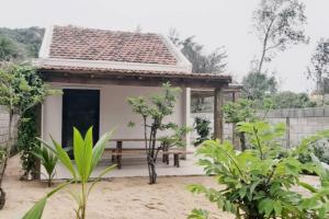 mały domek z ławką przed nim w obiekcie Moon homestay Phu Yen w mieście Phú Lac