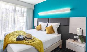 a hotel room with a bed with a hat on it at H&ocirc;tel Jardin Croisette in Cannes