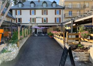 a walkway in front of a hotel with a building at Hôtel Le Dauphin in Villard-de-Lans