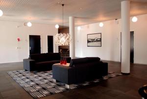 a living room with two couches and a chandelier at Hotel Nørherredhus in Nordborg