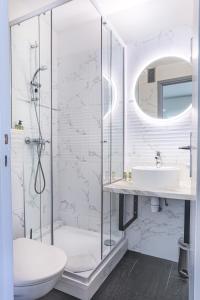 a bathroom with a shower and a toilet and a sink at Hôtel Jardin Croisette in Cannes