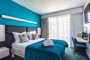 a hotel room with a bed with a blue wall at Hôtel Jardin Croisette in Cannes