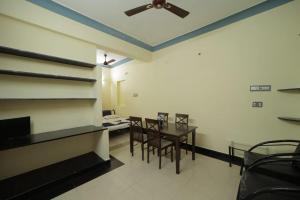 a dining room with a table and chairs and a ceiling fan at Karthik residence in Puducherry