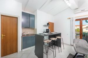 een keuken met een aanrecht en krukken in een kamer bij Apartman Tea in Novigrad Istria