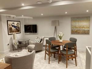 a living room with a table and chairs at Keswick Lake Road Apartments in Keswick