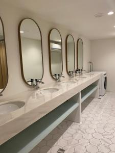 a bathroom with three sinks and four mirrors at 婧仕女微旅 in Hou-lung-tzu