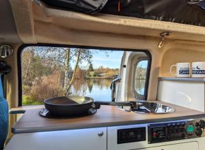 a frying pan sitting on top of a stove in an rv at Hire SCV in Warnham